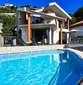 a swimming pool in front of a house at Vila Juntos by Your Madeira Rentals in Ponta do Sol