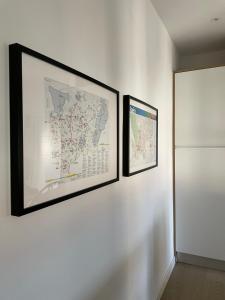 two framed maps are hanging on a white wall at AOVE Suite in Jaén