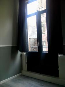 Una puerta con una ventana en una habitación en Room Aldo - not for parties, en Ámsterdam