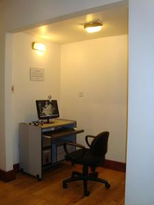 ein Büro mit einem Computertisch und einem Stuhl in der Unterkunft Rosa de los Viajes in San Martín de los Andes + 14 Fotos