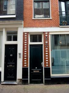 dos puertas negras en el lateral de un edificio de ladrillo en Room Aldo - not for parties, en Ámsterdam