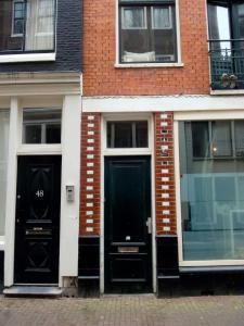 two black doors on the side of a brick building at ALDO, not for parties, not a hotel, room with shared bathroom, no kitchen in Amsterdam