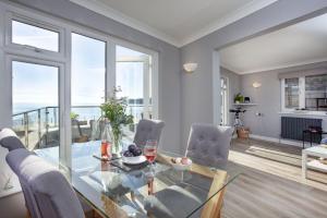 a dining room with a glass table and chairs at Atlantic View, Penzance in Penzance