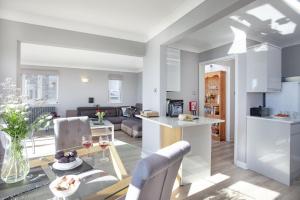a kitchen and a living room with a table at Atlantic View, Penzance in Penzance +19 photos