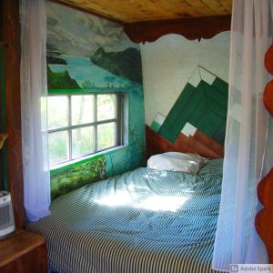 a bedroom with a bed with a painting on the wall at Les Patins à Roulottes in Yenne