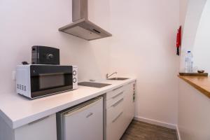 a kitchen with a microwave and a sink at Quinta da Bicuda in Cascais