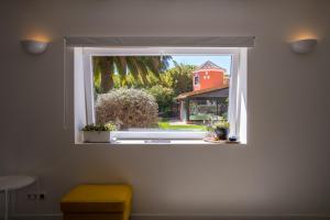 a window with potted plants and a red house at Quinta da Bicuda in Cascais