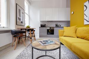 ロンドンにある2VH Virginia House, 31 Bloomsbury Way by City Living Londonのリビングルーム(黄色のソファ、テーブル付)