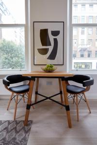 - une table avec 2 chaises et une corbeille de fruits dans l'établissement 2VH Virginia House, 31 Bloomsbury Way by City Living London, à Londres 12 autres photos