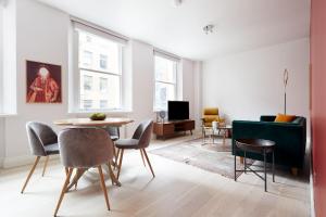 un soggiorno con tavolo, sedie e divano di 3VH Virginia House, 31 Bloomsbury Way by City Living London a Londra