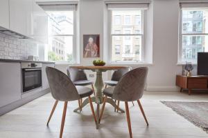 jadalnia ze stołem i krzesłami w obiekcie 3VH Virginia House, 31 Bloomsbury Way by City Living London w Londynie