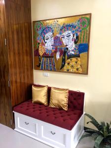 a red bench with a painting on the wall at PANIDA@AVANTA in Koh Samui 