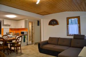 a living room with a couch and a table at Irma- forrás Vendégházak in Verőce