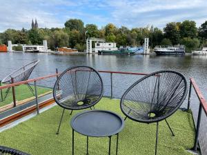two benches sitting on top of a grass covered field at Houseboat Ginger Prague in Prague