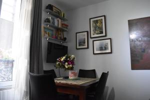 a dining room table with chairs and a vase of flowers at Charming Apartment near The Eiffel Tower in Paris