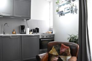 パリにあるCharming Apartment near The Eiffel Towerのキッチン(椅子、シンク、コンロ付)