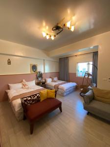 a hotel room with two beds and a couch at Beauty Home Homestay in Hualien City