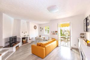 a living room with a yellow couch and a television at SARA E MELISSA HOUSE LIERNA in Lierna