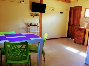 een eetkamer met een blauwe tafel en groene stoelen bij Los Neneos Chalten in El Chalten