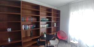 una habitación con una mesa y un estante de libros en B&B Le Ortensie en Cosenza