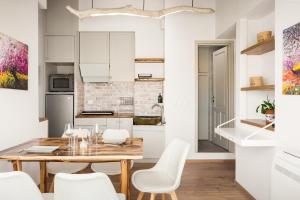 a kitchen and dining room with a wooden table and white chairs at Sky Loft Corfu Old Town Apartments in Corfu