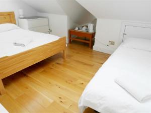 1 dormitorio con 2 camas y suelo de madera en Kew Studios and Rooms, en Kew