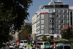 una trafficata strada cittadina con auto e autobus di Vatan Asur Hotel a Istanbul