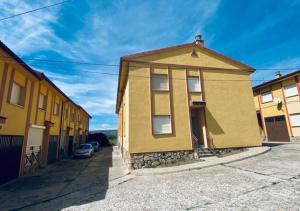 una casa amarilla al lado de una calle en CASA LOS PILARES, en San Bartolomé de Pinares