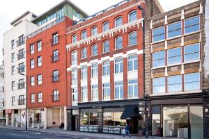 een groot bakstenen gebouw in een stadsstraat bij Heinze Flat 402 - One bedroom fourth floor flat By City Living London in Londen