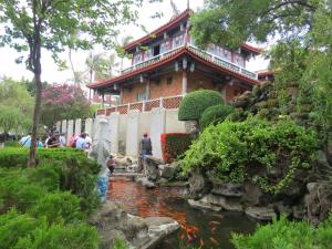 a building with a koi pond in a garden at @ Tainan Inn in Tainan