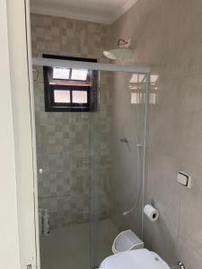 a bathroom with a glass shower with a toilet at casa 300 mts da praia in Juquei +18 photos
