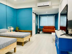 a hospital room with two beds and a television at Grasshopper Bed and Cafe in Pak Kret