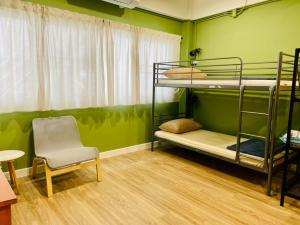 パックレにあるGrasshopper Bed and Cafeの二段ベッド2台と椅子が備わる客室です。