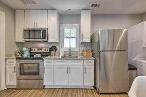 eine Küche mit weißen Schränken und einem Kühlschrank aus Edelstahl in der Unterkunft Updated Savannah Apartment - Walk to Forsyth Park! in Savannah