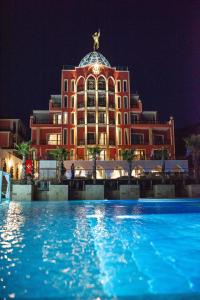 un edificio con una piscina di fronte ad essa di notte di Alchemist Residence Von Goldenburg a Plovdiv