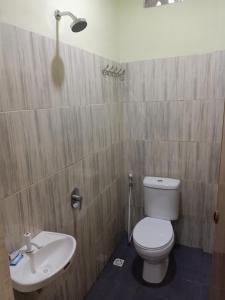 een badkamer met een toilet en een wastafel bij Wisma Cemara Dumai in Dumai