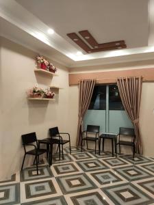 een wachtkamer met stoelen en een tafel en ramen bij Wisma Cemara Dumai in Dumai