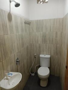 łazienka z toaletą i umywalką w obiekcie Wisma Cemara Dumai w Dumai