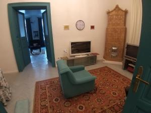 a living room with a chair and a television at Затишна квартира в історичному Центрі міста in Chernivtsi