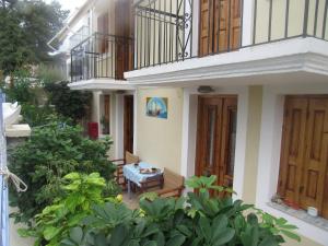 a house with a balcony and a table on a patio at Chryssa Rooms in Symi