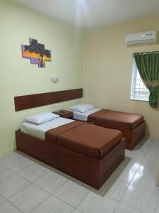 ein Schlafzimmer mit 2 Betten und einem Wandgemälde in der Unterkunft Wisma Cemara Dumai in Dumai