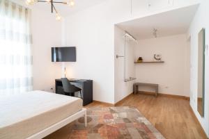 a bedroom with a bed and a desk and a tv at L'isola che c'è in Cagliari