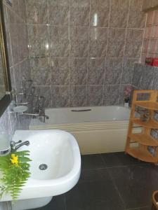 a bathroom with a white sink and a bath tub at Kai Selfcatering in La Digue