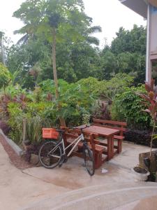 una bicicletta parcheggiata accanto a un tavolo da picnic e a una panchina di Kai Selfcatering a La Digue