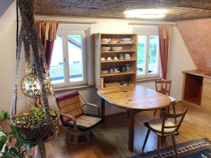 Das blaue Haus في بفولندورف: غرفة طعام مع طاولة وكراسي ونوافذ