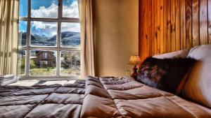a bed sitting in a room with a window at Hotel Lago del Desierto in El Chalten