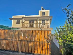 a house with a wooden fence in front of it at Tenexia - Morne Brabant Studio in La Gaulette