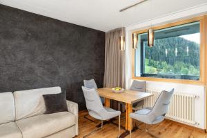 salon z kanapą, stołem i krzesłami w obiekcie Residence Catarina Lanz w mieście San Vigilio di Marebbe