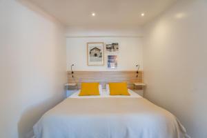 a bedroom with a large bed with two yellow pillows at Quinta da Bicuda in Cascais