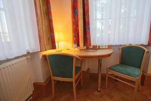 ein kleiner Tisch und zwei Stühle in einem Zimmer in der Unterkunft Hotel Restaurant Hambacher WInzer in Neustadt an der Weinstraße